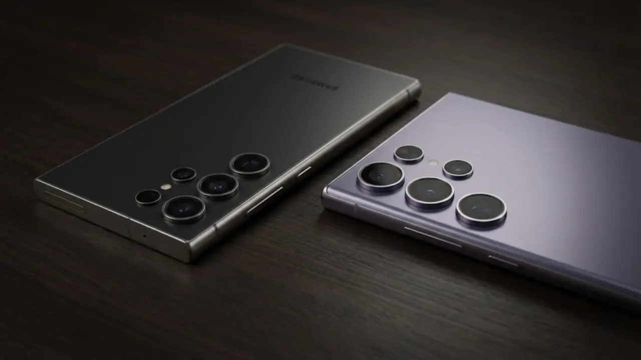 Back view of the new Samsung Galaxy S26 Ultra in Titanium Purple next to the Galaxy S25 Ultra in Black on a wooden desk, comparing their camera ring designs and slimness. Full comparison in Telugu.